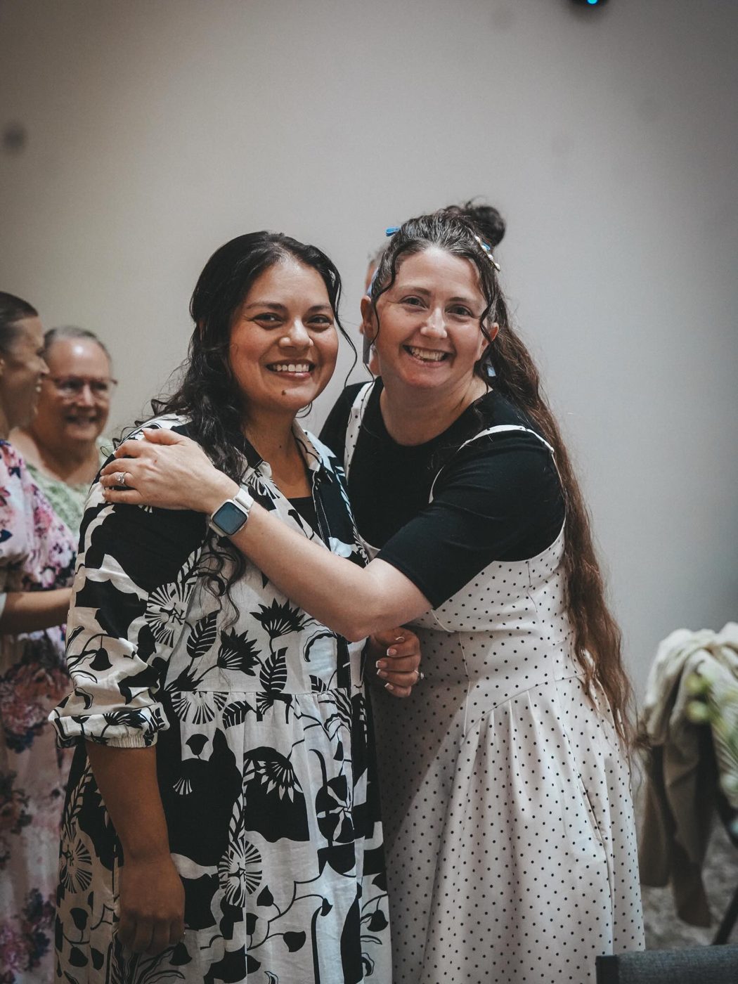 Two friends hugging and smiling at church