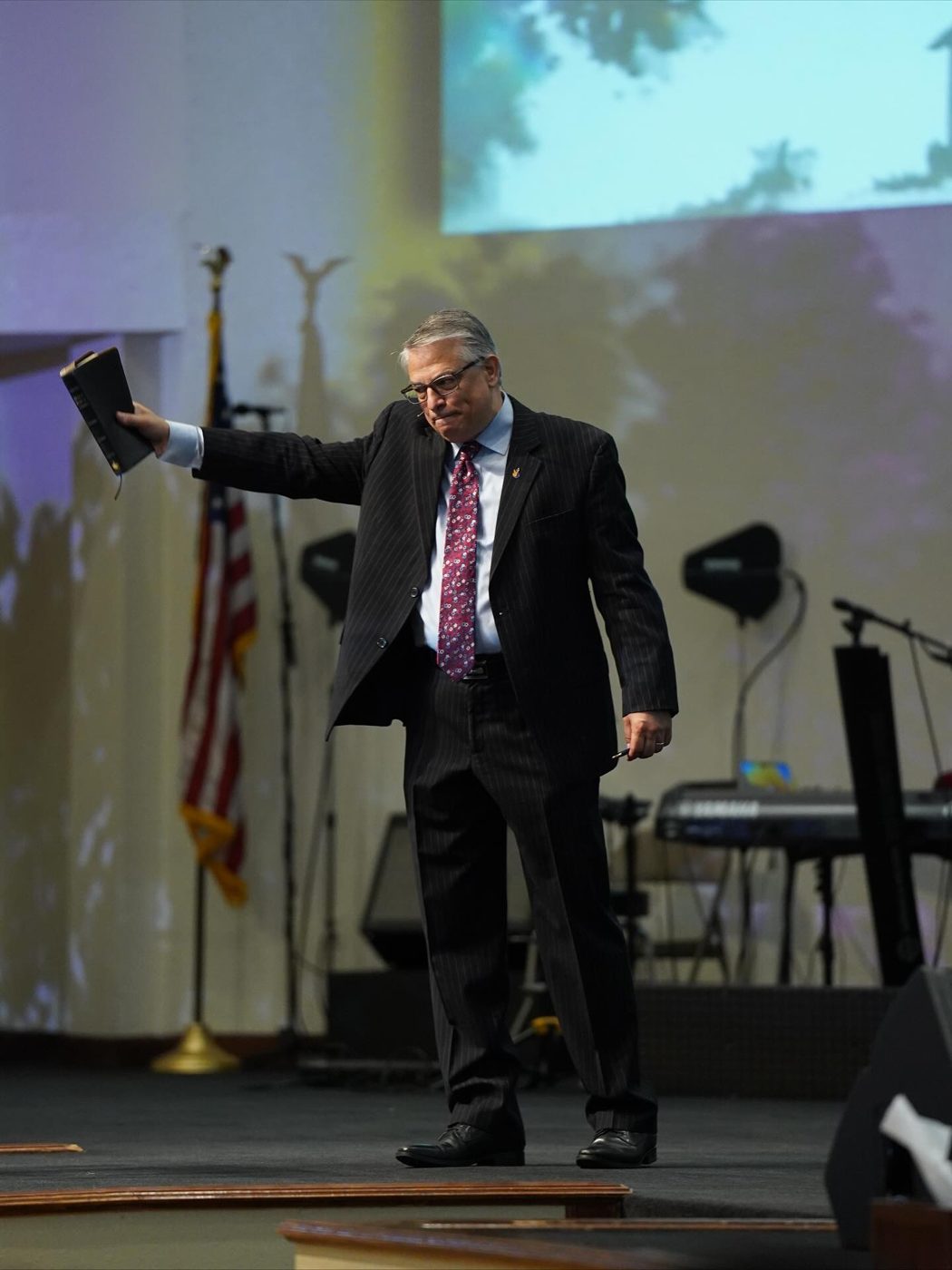 Pastor Mark Hattabaugh preaching with his Bible raised