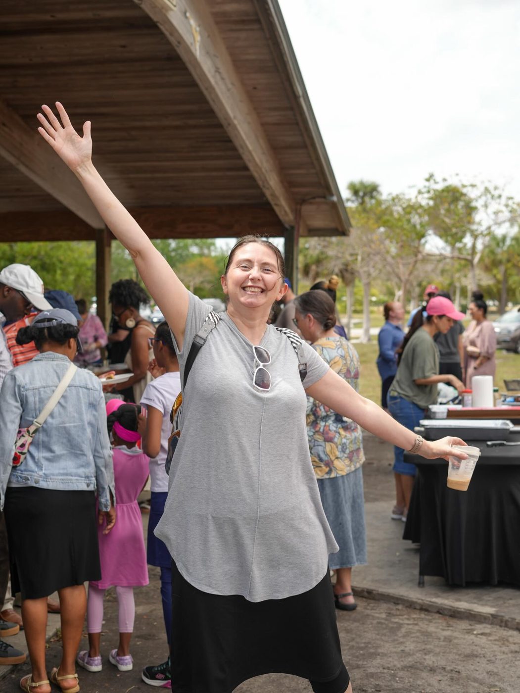 A woman celebrating with arms wide open at the church picnic