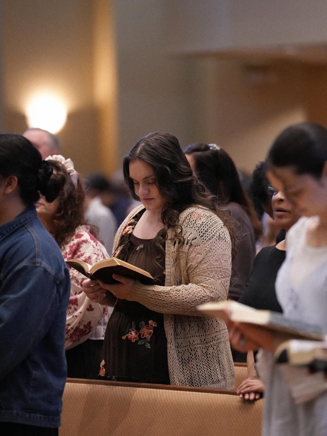 Women following along in their Bibles during service